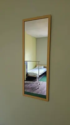 a mirror on a wall with a bed in a room at Charlemagne house in Liège