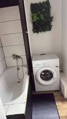 a bathroom with a washing machine and a bath tub at Bayards 41 in Liège
