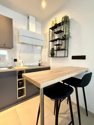 a kitchen with a wooden table and two chairs at Charming studio in the heart of Liege - total comfort in Liège