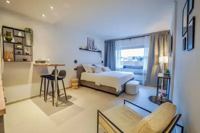 a bedroom with a bed and a table and a window at Charming studio in the heart of Liege - total comfort in Liège