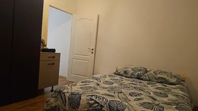 a bedroom with a bed and a dresser and a door at Logement Sam in Liège