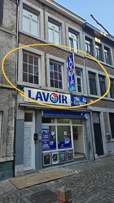 a building with a large sign in front of it at Logement Sam in Liège