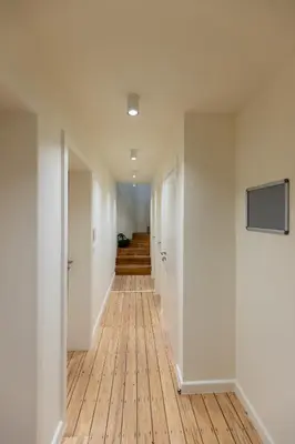 a hallway with white walls and a wooden floor at Theodore Schwann - duplex centre de Liège in Liège