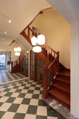 a lobby with a staircase and a checkered floor at Theodore Schwann - duplex centre de Liège in Liège