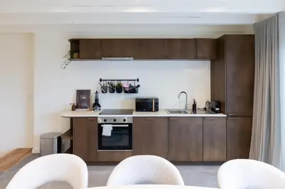 a kitchen with wooden cabinets and a counter top at Theodore Schwann - duplex centre de Liège in Liège