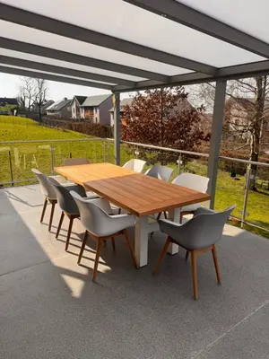 a wooden table and chairs under a canopy at Haus Orion in Eupen