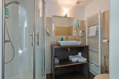 a bathroom with a sink and a shower at Hotel Brasserie de Klok in Zutendaal