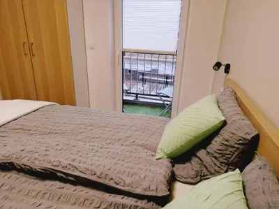 a bed with green pillows and a window in a room at Riverside Holiday in Eupen