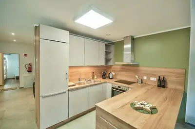 a kitchen with white cabinets and a wooden counter top at Riverside Holiday in Eupen