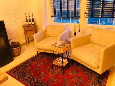a living room with two chairs and a table at Maison Lion Luxe vakantiewoning in Borgloon