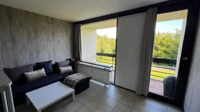 a living room with a couch and a large window at Serene Oasis - your Idyllic Escape in La Calamine