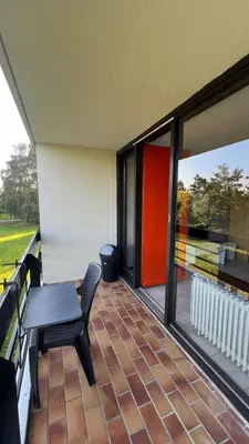 a room with a table and a chair on a balcony at Serene Oasis - your Idyllic Escape in La Calamine