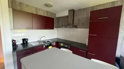 a kitchen with red cabinets and a white counter top at Serene Oasis - your Idyllic Escape in La Calamine