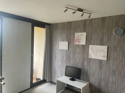 a room with a television on a wall with a table at Serene Oasis - your Idyllic Escape in La Calamine