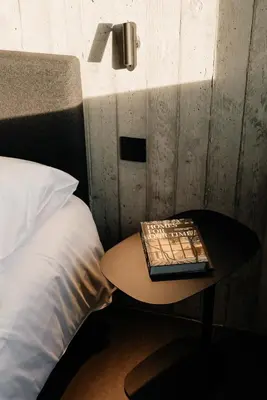 a table with a book on it next to a bed at Coliving - Bord de Meuse - L'échappée Mosane in Oupeye