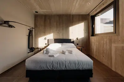 a bedroom with a large bed with a window at Coliving - Bord de Meuse - L'échappée Mosane in Oupeye