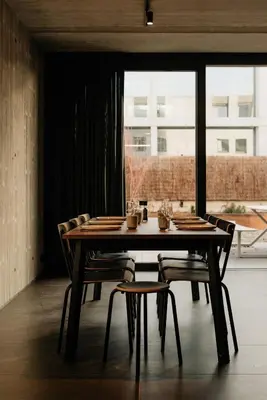 a dining room table with chairs and a large window at Coliving - Bord de Meuse - L'échappée Mosane in Oupeye