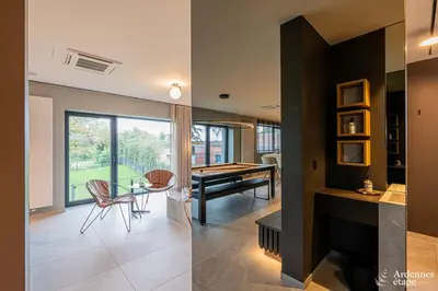 two pictures of a living room with a pool table at Loft La Suite et sa Suite in Thimister