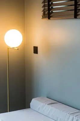 a lamp next to a bed in a room at Loft La Suite et sa Suite in Thimister