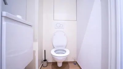 a bathroom with a white toilet in a stall at Appartement en plein centre-ville in Liège