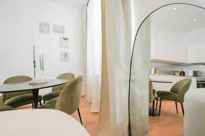a room with a table and chairs and a mirror at Appartement en plein centre-ville in Liège