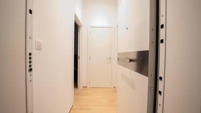 a hallway with white walls and a wooden floor at Appartement en plein centre-ville in Liège