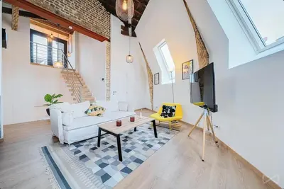 a living room with a white couch and a tv at Logement temporaire haut de gamme Particuliers & entreprises in Liège