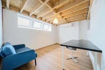 a living room with a table and a blue chair at Logement temporaire haut de gamme Particuliers & entreprises in Liège