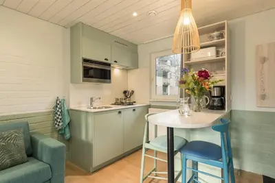 a kitchen with green cabinets and a table and chairs at Center Parcs Apartments Erperheide in Peer