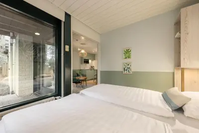 a bedroom with a bed and a large window at Center Parcs Apartments Erperheide in Peer