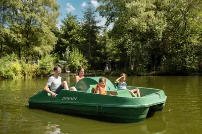 a group of people sitting in a green boat in the water at Center Parcs Apartments Erperheide in Peer