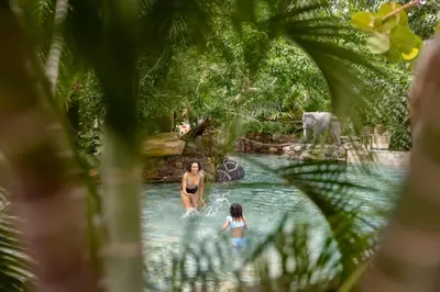 two people swimming in a pool at a theme park at Center Parcs Apartments Erperheide in Peer