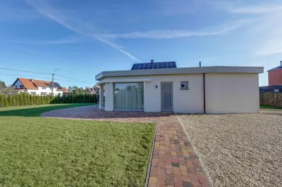 a small white building with a roof on a yard at 't Vennehuys in Genk