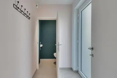 a bathroom with a toilet and a green wall at 't Vennehuys in Genk