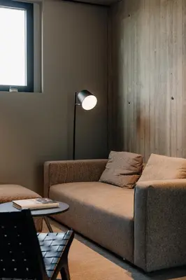 a living room with a couch and a lamp at Coliving - Bord de Meuse - L'écrin Vert in Oupeye