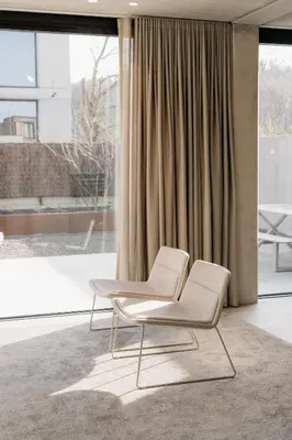 a white chair in a room with a large window at Coliving - Bord de Meuse - L'instant in Oupeye