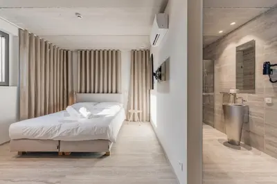 a bedroom with a white bed and a bathroom at Coliving - Bord de Meuse - L'instant in Oupeye