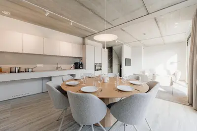 a dining room with a wooden table and chairs at Coliving - Bord de Meuse - L'instant in Oupeye