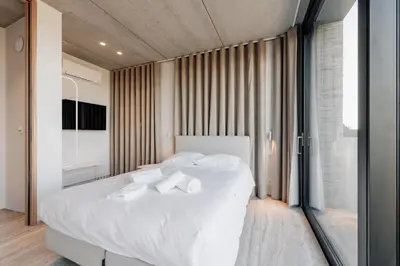 a bedroom with a white bed with white pillows at Coliving - Bord de Meuse - L'instant in Oupeye