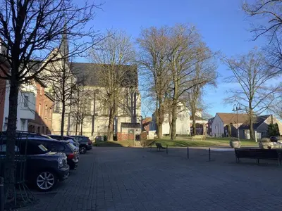 a large building with cars parked in a parking lot at Charming Apartment in Lontzen on 72 m² in Lontzen