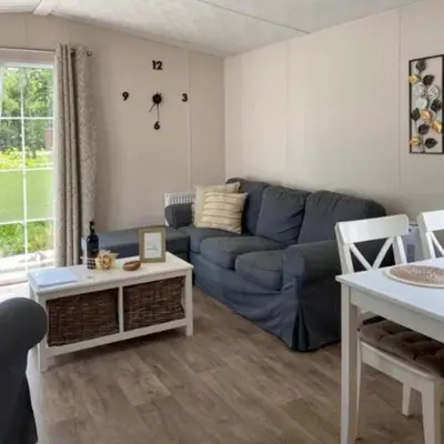 a living room with a blue couch and a table at Casa Nymphaea in Kinrooi