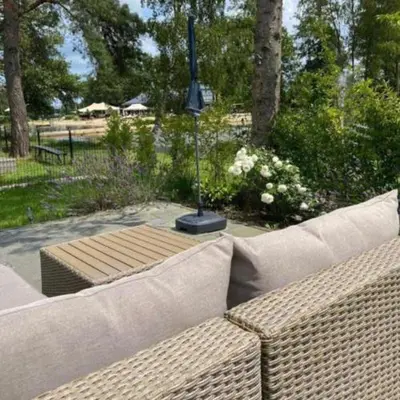 a couch sitting in front of a garden with a pole at Casa Nymphaea in Kinrooi