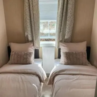 two beds in a room with a window at Casa Nymphaea in Kinrooi