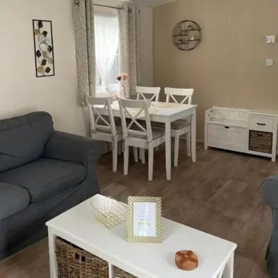 a living room with a couch and a table and chairs at Casa Nymphaea in Kinrooi
