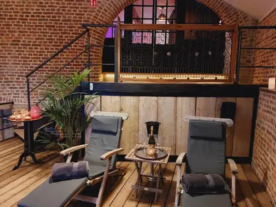 a patio with two chairs and a table and a staircase at Le Trèfle in Plombières