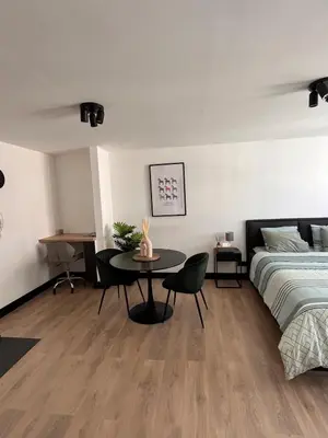 a bedroom with a bed and a table next to a bed at Studio moderne et confort - Guillemins in Liège
