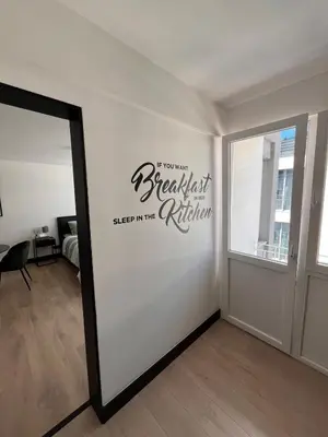a room with a white wall with a sign on it at Studio moderne et confort - Guillemins in Liège