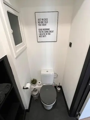 a bathroom with a toilet and a sign on the wall at Studio moderne et confort - Guillemins in Liège