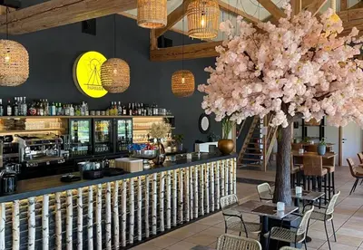 a restaurant with a bar with a large pink tree at Camping Papillon Kinrooi - Pipowagen 2p in Kinrooi