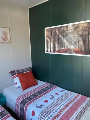 a bedroom with a bed with a picture on the wall at Camping Papillon Kinrooi - Vakantiehuis Familie 6P in Kinrooi